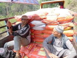 Narayan Ojha, a project coordinator for MCC's local partner SAHAS, and a local resident travel with relief items to the village of Khijifalate, Okhaldhunga. It's a 3-hour journey by tractors or motorbikes. The alternative is on foot. This tractor had to make 5 trips over 2 days to get all the relief materials from the trucks at the main road to Khijifalate village. (MCC photo/Durga Sunchiuri)